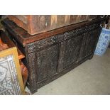 AN OAK COFFER, THE FRONT WITH CARVED FOLIATE PANELS
