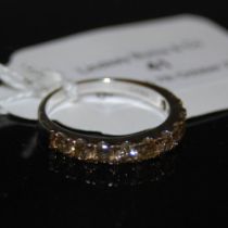 A STERLING SILVER CHAMPAGNE COLOURED DIAMOND RING, SET WITH TEN ROUND CUT CHAMPAGNE COLOURED