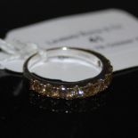 A STERLING SILVER CHAMPAGNE COLOURED DIAMOND RING, SET WITH TEN ROUND CUT CHAMPAGNE COLOURED