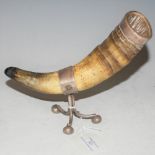 A WHITE METAL MOUNTED HORN ON THREE SHAPED SUPPORTS WITH BUN FEET