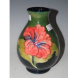 A MOORCROFT GREEN GROUND POTTERY VASE DECORATED WITH STYLISED FLOWERS