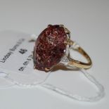A 9CT GOLD RED ASTRAEOLITE AND DIAMOND RING, CENTRED WITH A MARQUISE CUT RED ASTRAEOLITE ESTIMATED