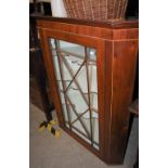 A MAHOGANY HANGING CORNER CABINET WITH ASTRAGAL GLAZED DOOR OPENING TO THREE SERPENTINE SHELVES