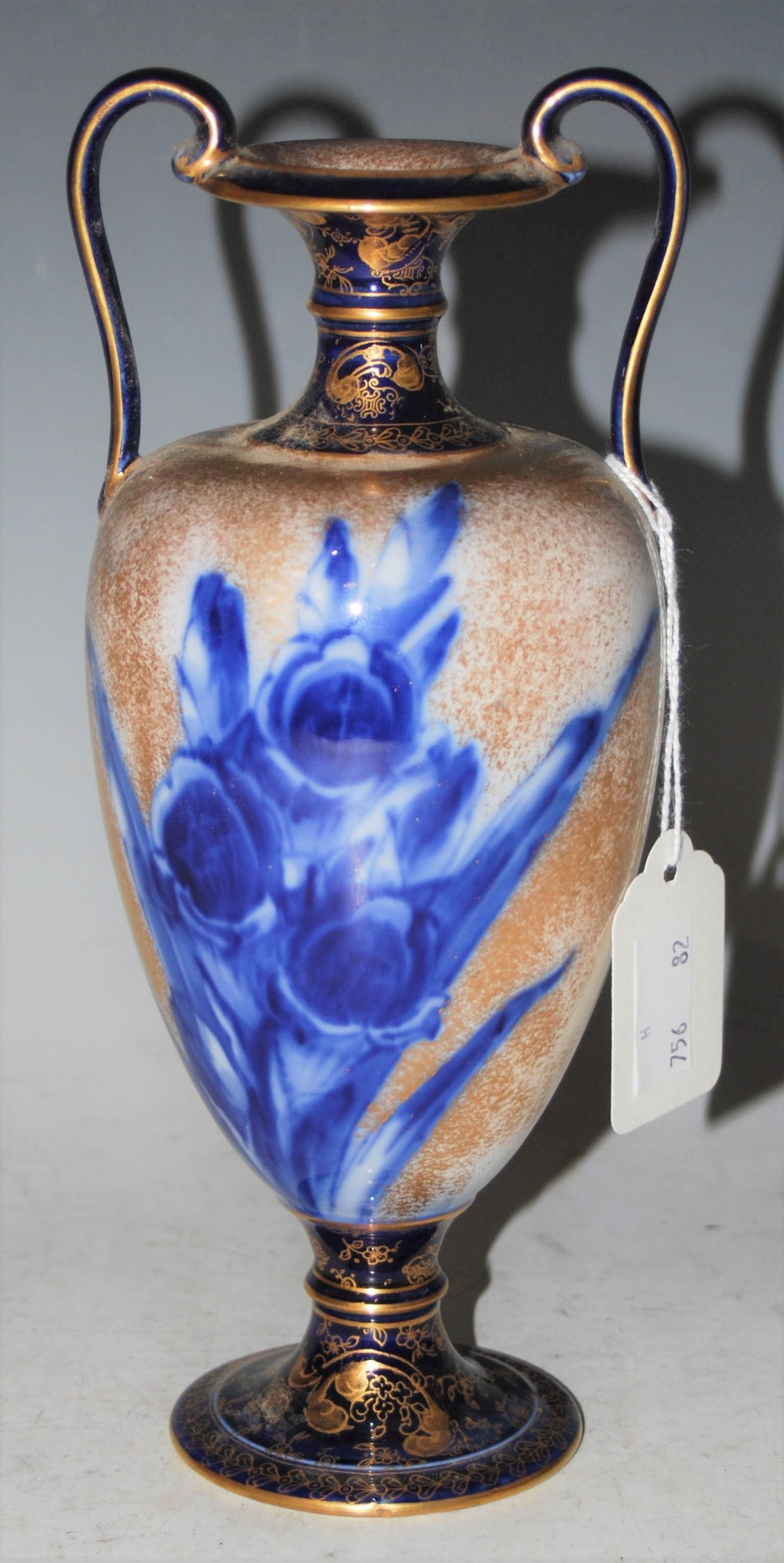 A DOULTON BURSLEM BLUE AND WHITE TWIN HANDLED POTTERY URN WITH GILDED DECORATION