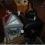 A DECORATIVE LEADED GLASS HANGING LIGHT AND A BLACK PAINTED LANTERN WITH CLEAR AND RED GLASS PANELS