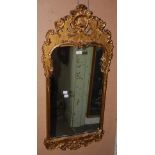 A 20TH CENTURY GILTWOOD RECTANGULAR WALL MIRROR WITH SHELL CARVED SURMOUNT