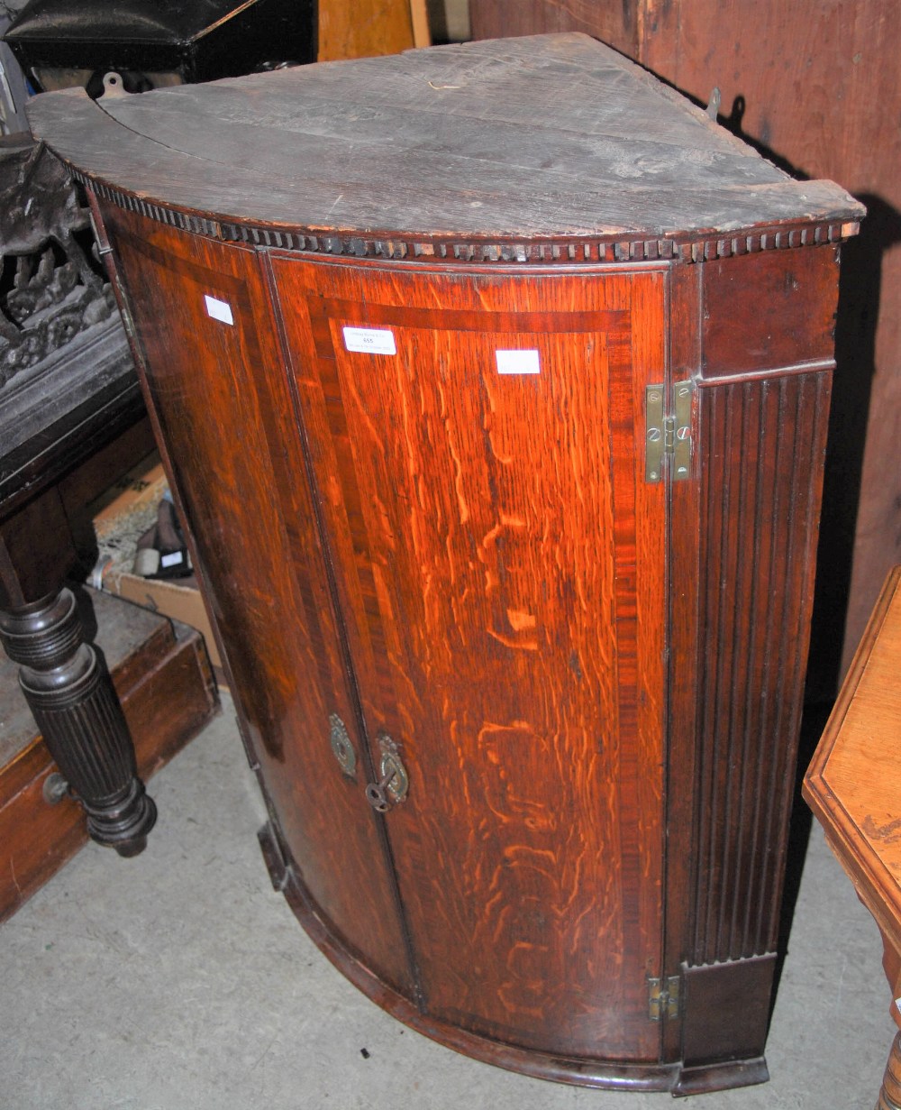 A 19TH CENTURY OAK HANGING CORNER CUPBOARD WITH DENTIL FRIEZE AND FLUTED COLUMN DETAIL