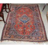 A PERSIAN RUG, THE RECTANGULAR MADDER GROUND CENTRED WITH A LARGE BLUE GROUND MEDALLION WITHIN A