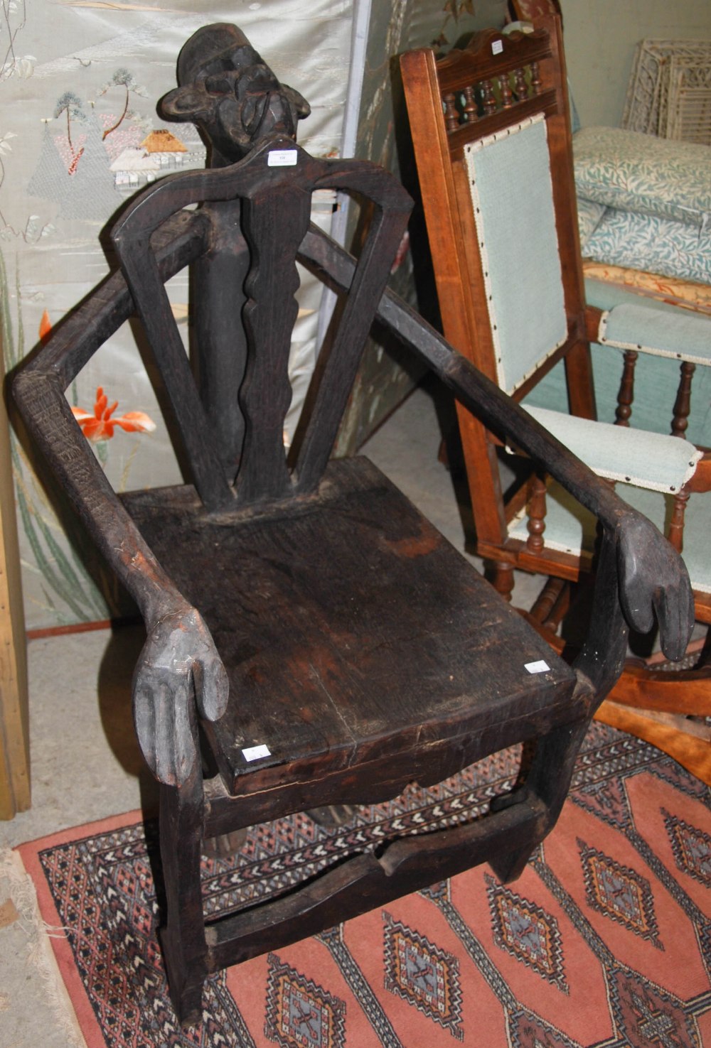 TRIBAL ART: A CARVED WOOD STOOL IN THE FORM OF A KNEELING FIGURE WITH PIERCED BACK AND SOLID SEAT