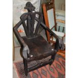 TRIBAL ART: A CARVED WOOD STOOL IN THE FORM OF A KNEELING FIGURE WITH PIERCED BACK AND SOLID SEAT