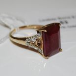 A 9CT GOLD RUBY AND DIAMOND RING, CENTRED WITH OCTAGON SHAPED RUBY ESTIMATED TO WEIGH 9.46CTS, THE