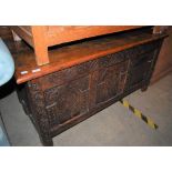 AN OAK COFFER, THE FRONT WITH CARVED FLORAL PANELS