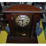 AN AMERICAN OAK CASED MANTLE CLOCK WITH ROMAN NUMERAL DIAL