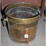 A TWIN-HANDLED BRASS FUEL BIN WITH PIERCED FRIEZE DETAIL