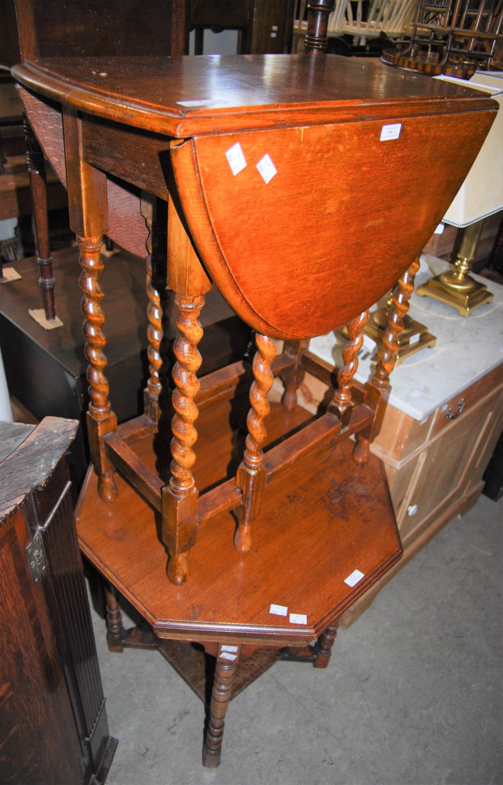 A 20TH CENTURY STAINED OAK DROP LEAF TABLE ON BARLEY TWIST SUPPORTS, TOGETHER WITH AN OCTAGONAL