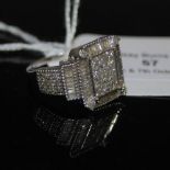 A 9CT WHITE GOLD AND DIAMOND ART DECO STYLE TOMAS RAE RING, CENTRED WITH A RECTANGULAR PANEL