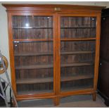 A VINTAGE PINE BOOKCASE WITH TWO GLAZED CUPBOARD DOORS AND FITTED INTERIOR OF OPEN SHELVES WITH