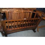 A HARDWOOD ROCKING COT WITH CARVED COCKEREL DECORATION