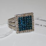 A 9CT WHITE GOLD BLUE AND WHITE DIAMOND RING, CENTRED WITH A SQUARE SHAPED PANEL ENCLOSING THIRTY