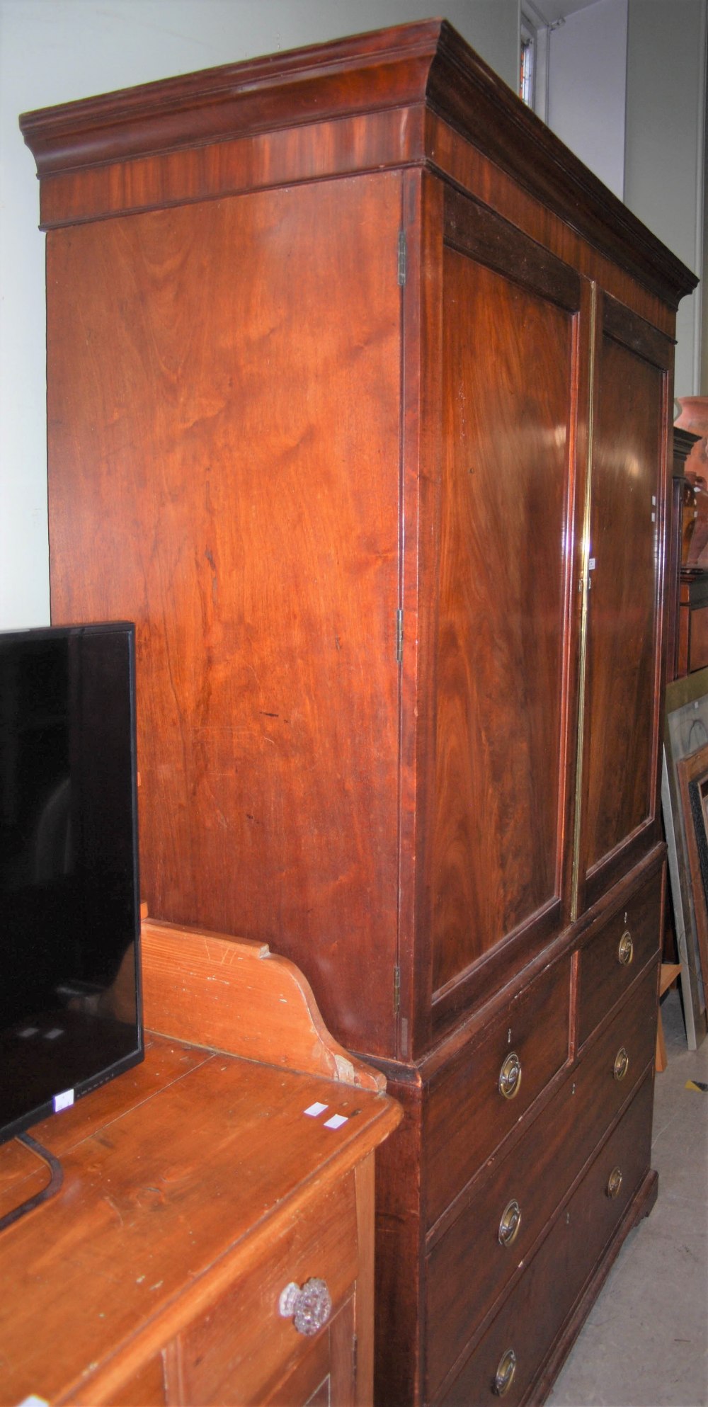 AN ANTIQUE MAHOGANY LINEN PRESS, THE TOP WITH TWO CUPBOARD DOORS OPENING TO THREE SLIDING SHELVES,