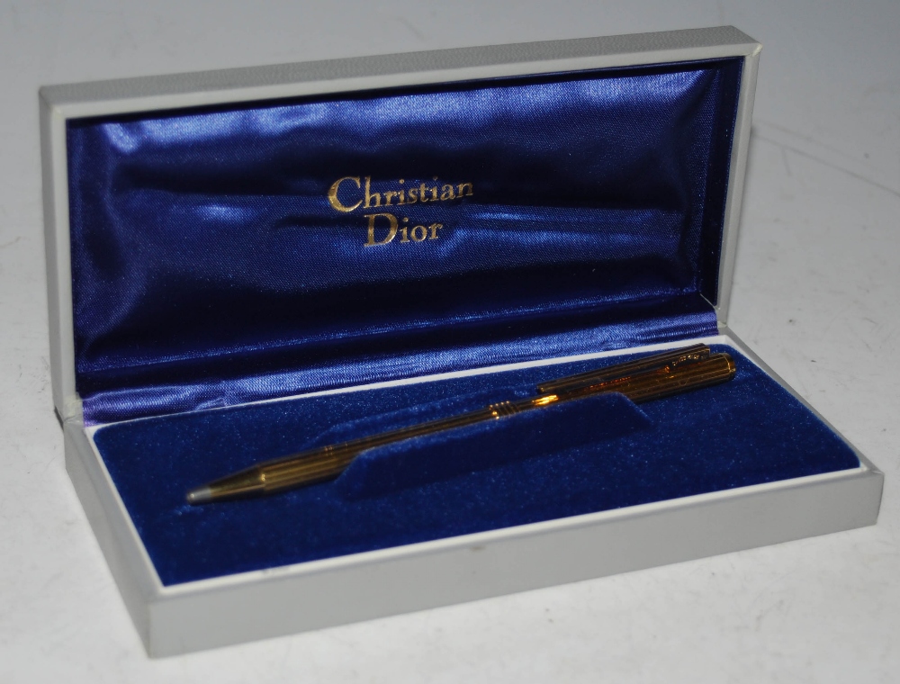 A VINTAGE YELLOW METAL BALL POINT PEN BY CHRISTIAN DIOR IN ORIGINAL BOX