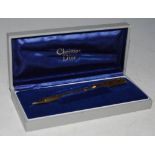 A VINTAGE YELLOW METAL BALL POINT PEN BY CHRISTIAN DIOR IN ORIGINAL BOX