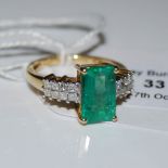 AN 18CT GOLD COLUMBIA EMERALD AND DIAMOND RING, CENTRED WITH A BAGUETTE CUT COLUMBIA EMERALD