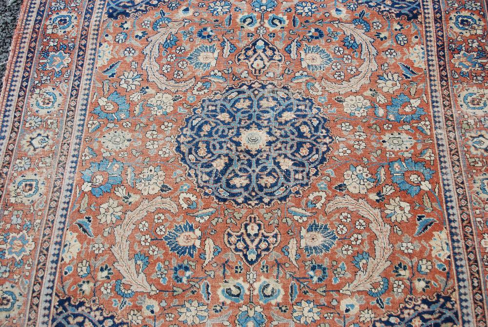 AN ANTIQUE PERSIAN CARPET, THE MADDER FIELD WITH PALMETTES AND SCROLLING FLORAL ARABESQUES WITH A - Image 6 of 9