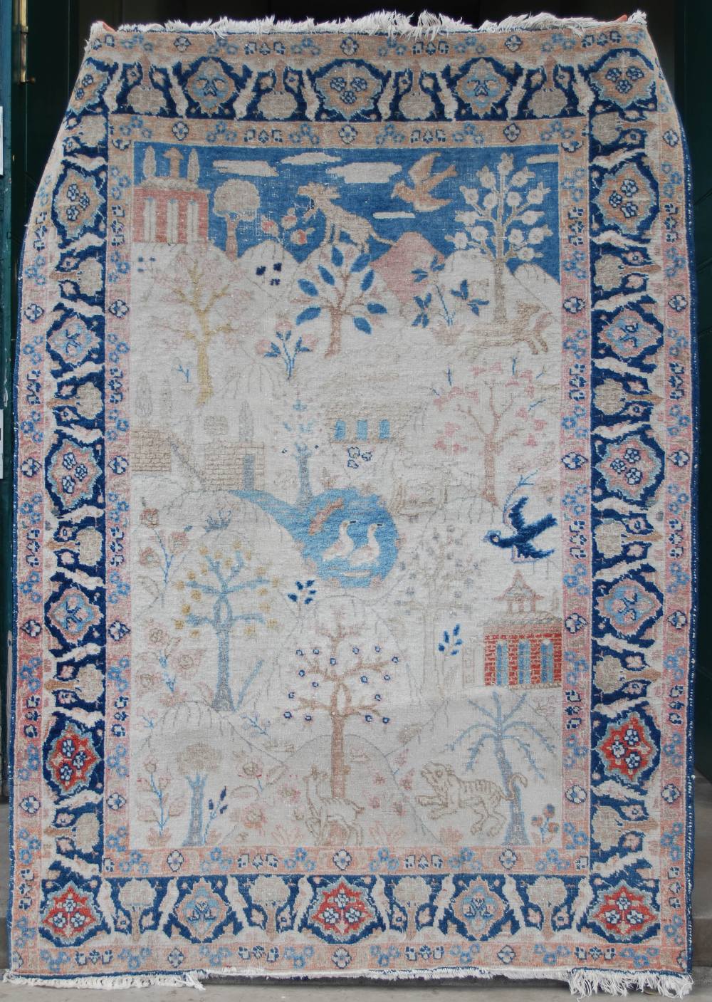 A PERSIAN RUG, LATE 19TH / EARLY 20TH CENTURY, THE RECTANGULAR GROUND DECORATED WITH TREES,