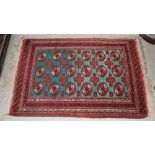 A SMALL PERSIAN RUG, THE RECTANGULAR GREEN GROUND DECORATED WITH THREE ROWS OF SIX OCTAGONAL
