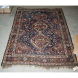 A PERSIAN RUG, THE BLUE RECTANGULAR GROUND CENTRED WITH THREE LOZENGE SHAPED MEDALLIONS WITHIN A