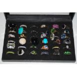 A BLACK AND GILT RING BOX CONTAINING THIRTY SIX ASSORTED RINGS WITH SEMI PRECIOUS GEM STONE DETAIL