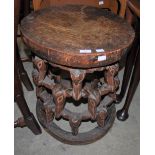 TRIBAL ART; A CARVED AND STAINED WOOD CIRCULAR STOOL WITH STYLISED ANIMAL MASK DETAIL