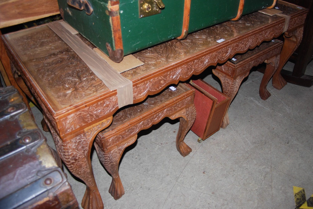 AN INDIAN CARVED WOOD COFFEE TABLE WITH GLASS INSERT AND TWO MATCHING SIDE TABLES TOGETHER WITH A