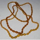 THREE ASSORTED AMBER TYPE BEAD NECKLACES