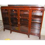 A MAHOGANY GLAZED BOOKCASE, THE CENTRE SECTION WITH DOUBLE DOORS FLANKED BY TWO SINGLE DOORS, ALL