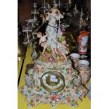 A PORCELAIN FLOWER-ENCRUSTED MANTLE CLOCK WITH FIGURAL AND PUTTI SURMOUNT