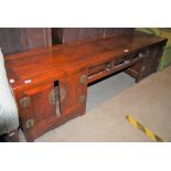 A CHINESE LOW TABLE, THE CENTRE SECTION WITH THREE SMALL DRAWERS FLANKED BY TWO CUPBOARD DOORS AT