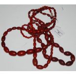 TWO RED COLOURED AMBER TYPE BEAD NECKLACES