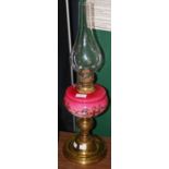 A LATE 19TH CENTURY PARAFFIN BURNING OIL LAMP WITH OPAQUE PINK RESERVOIR AND CLEAR GLASS FUNNEL