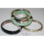 A COLLECTION OF BANGLES TO INCLUDE A WHITE METAL MOUNTED JADE BANGLE, A HEAVY GAUGE SILVER BANGLE