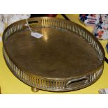 A 19TH CENTURY BRASS OVAL DRINKS TRAY WITH PIERCED GALLERY AND FOUR BUN FEET