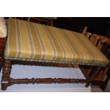 A WALNUT RECTANGULAR UPHOLSTERED STOOL WITH TURNED SUPPORTS