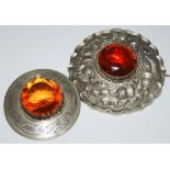 TWO WHITE METAL PLAID BROOCHES, EACH CENTRED WITH ORANGE COLOURED FACET-CUT STONE