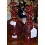 A PAIR OF SMALL CRANBERRY GLASS DECANTERS AND STOPPERS