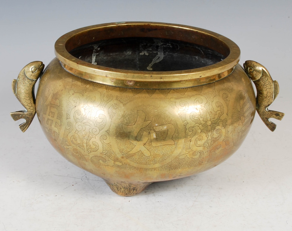 A Chinese bronze censer, of circular form, raised on three prong feet with applied fish shaped