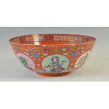 A Chinese porcelain red ground bowl, late 19th/ early 20th century, decorated with panels of