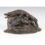 An early 20th century bronze figure of a crocodile on a rock, 25cm wide x 12cm high.