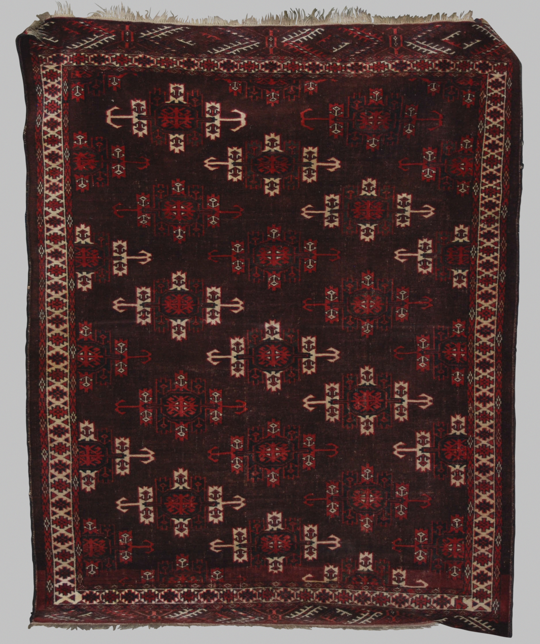 A Persian rug, 20th century, the earth coloured ground decorated with stylised octagonal shaped