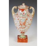 A Chinese porcelain twin-handled urn and cover, Qing Dynasty, decorated with two oval shaped